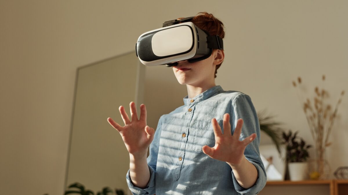 Ein Kind mit VR-Brille und abwehrender Haltung